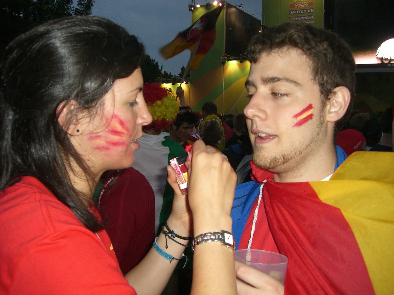 Ángel getting painted with the national colors (from the German flag)